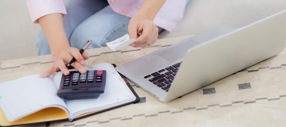 Manos revisando una cuenta con una calculadora