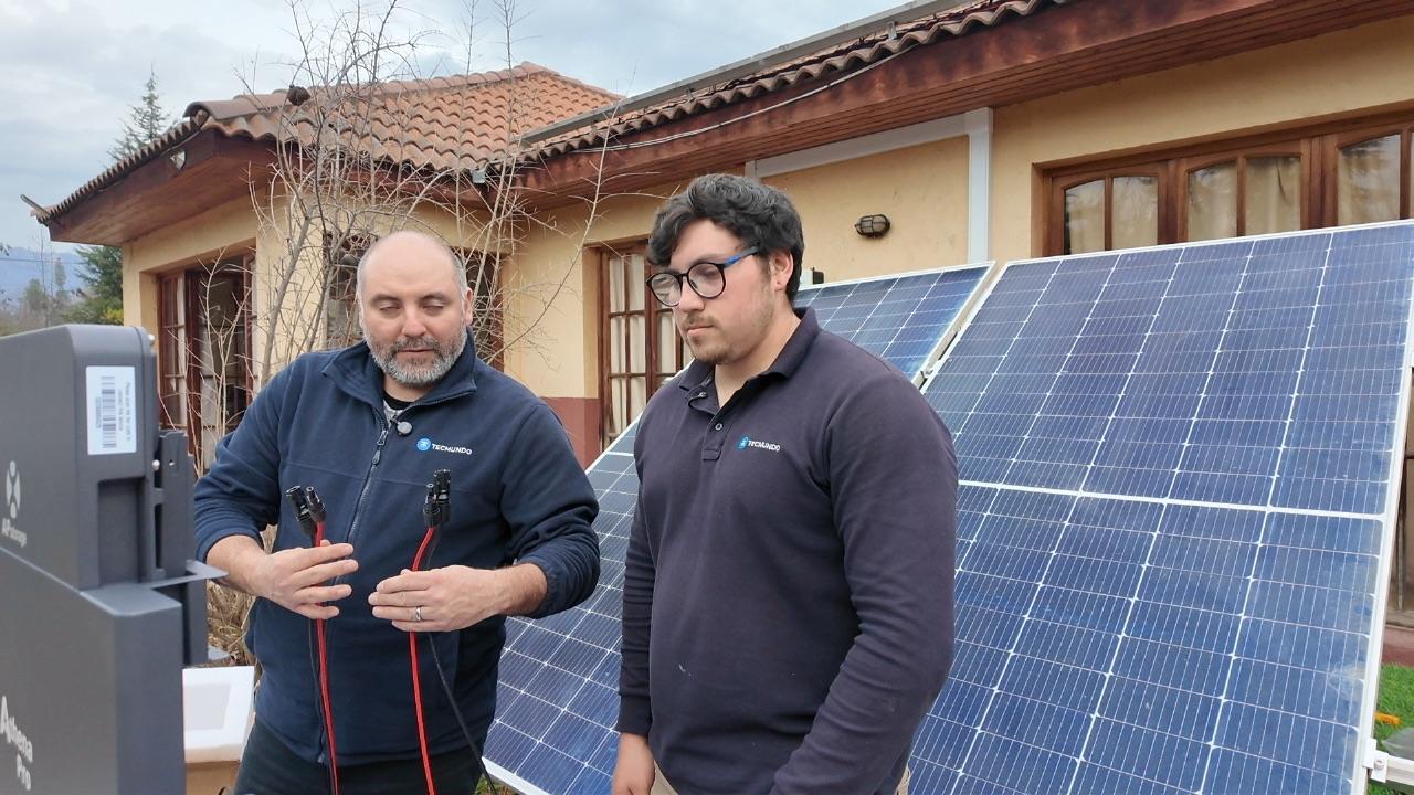 Técnico de Tecmundo explica el cableado a otra persona junto a los paneles